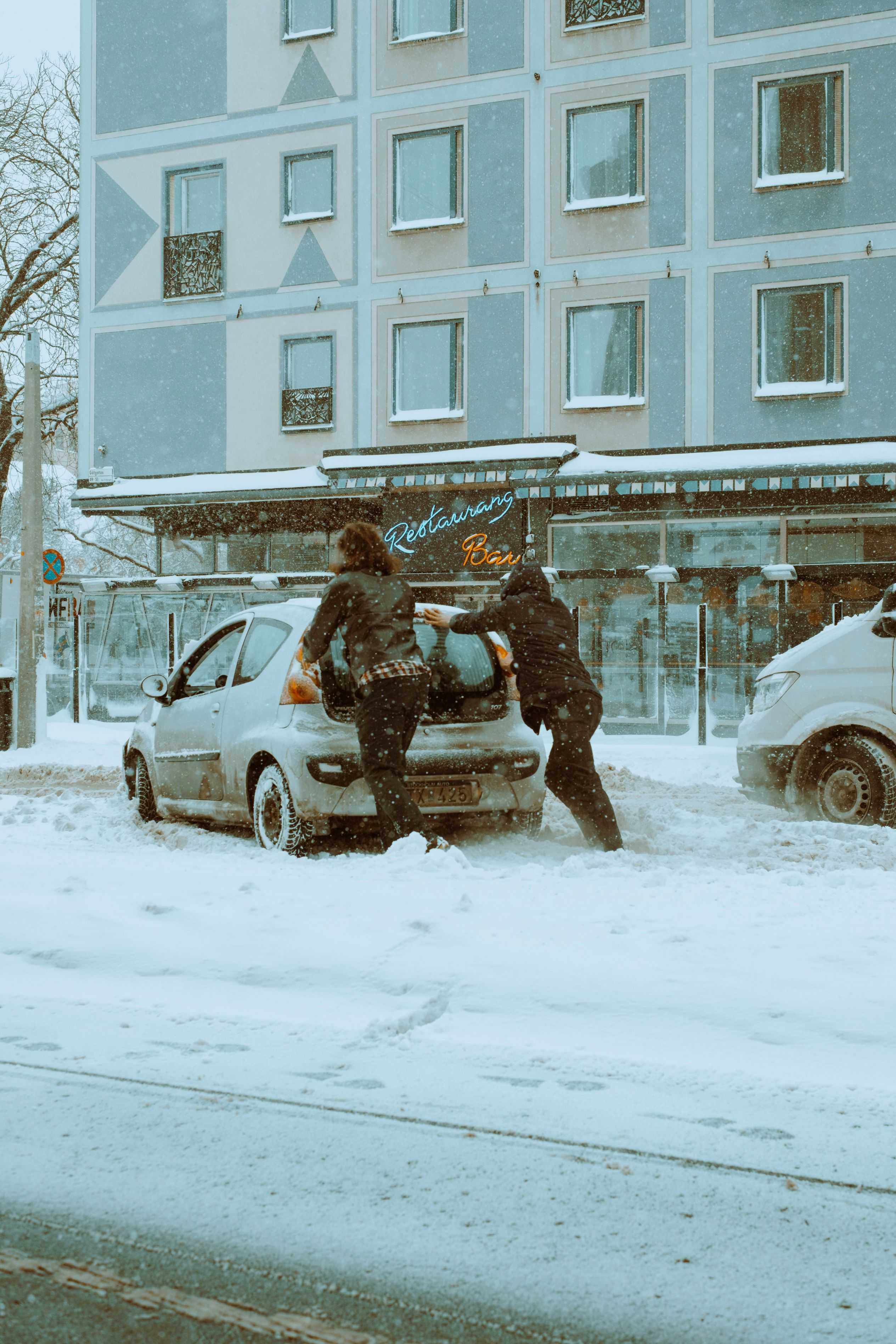 Skrapa bilen i snön och vinterväder med en bilförsäkring jämförd på happens